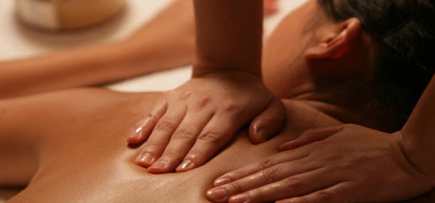 a woman's back with two hands massaging it
